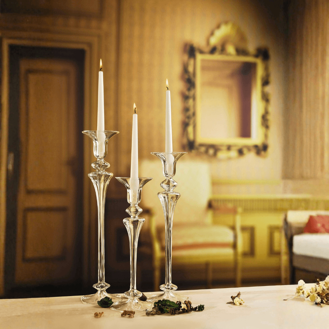 Decorative candlesticks with white candles on a table in an elegant room.